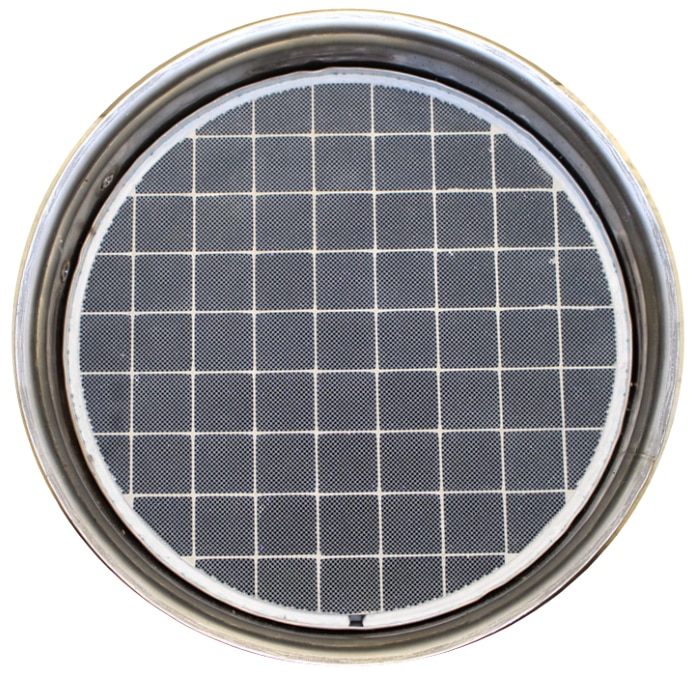 A photograph of a silicon carbide (SiC) DPF, which is dark grey and made of multiple square elements